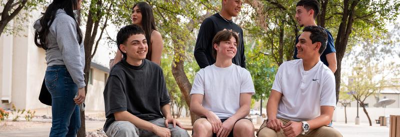 6 students converse in a campus courtyard
