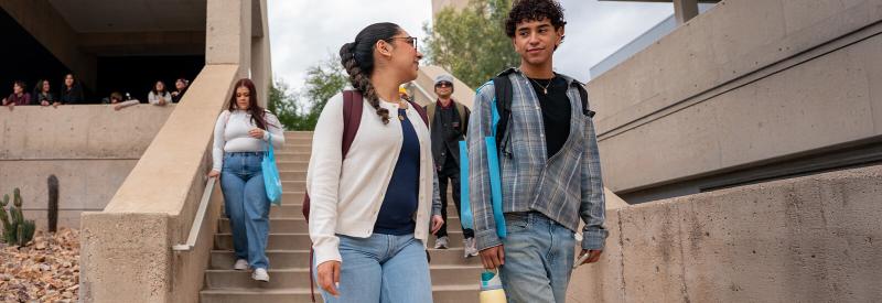 Two Students walk in a west campus courtyard