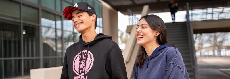 Two students stand laughing in a Downtown Campus Courtyard