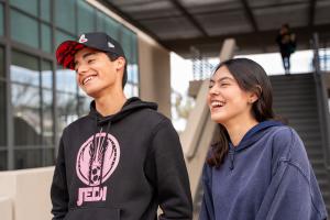 Two students stand laughing in a Downtown Campus Courtyard